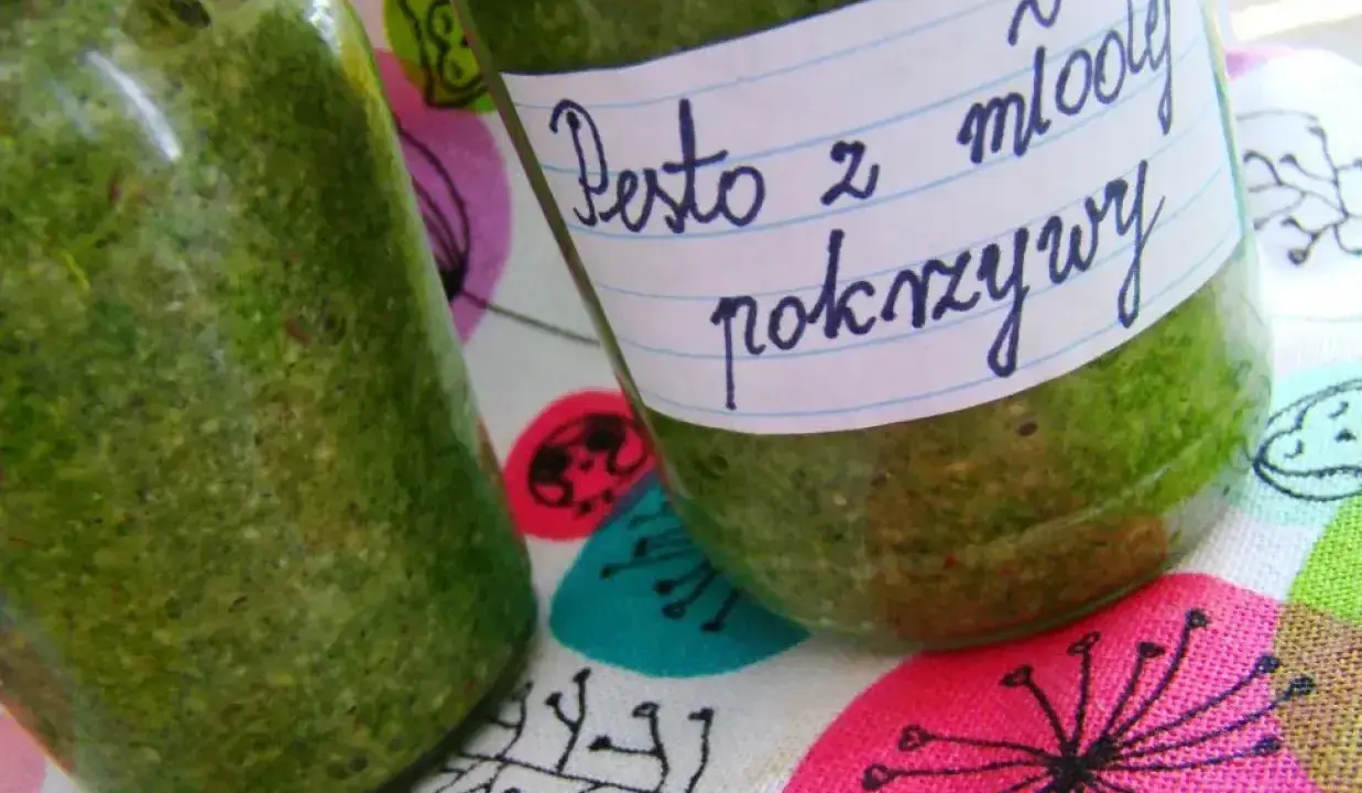 Dwa słoiki z zielonym pesto z pokrzywy, jedno z etykietą "Pesto z młodej pokrzywy".