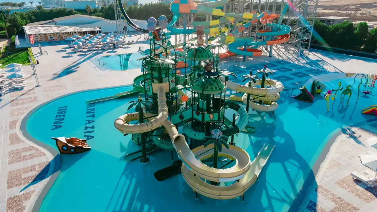 Kolorowy aquapark Fantazia Resort Marsa Alam z licznymi zjeżdżalniami i basenami, w tym z motywem statku pirackiego.