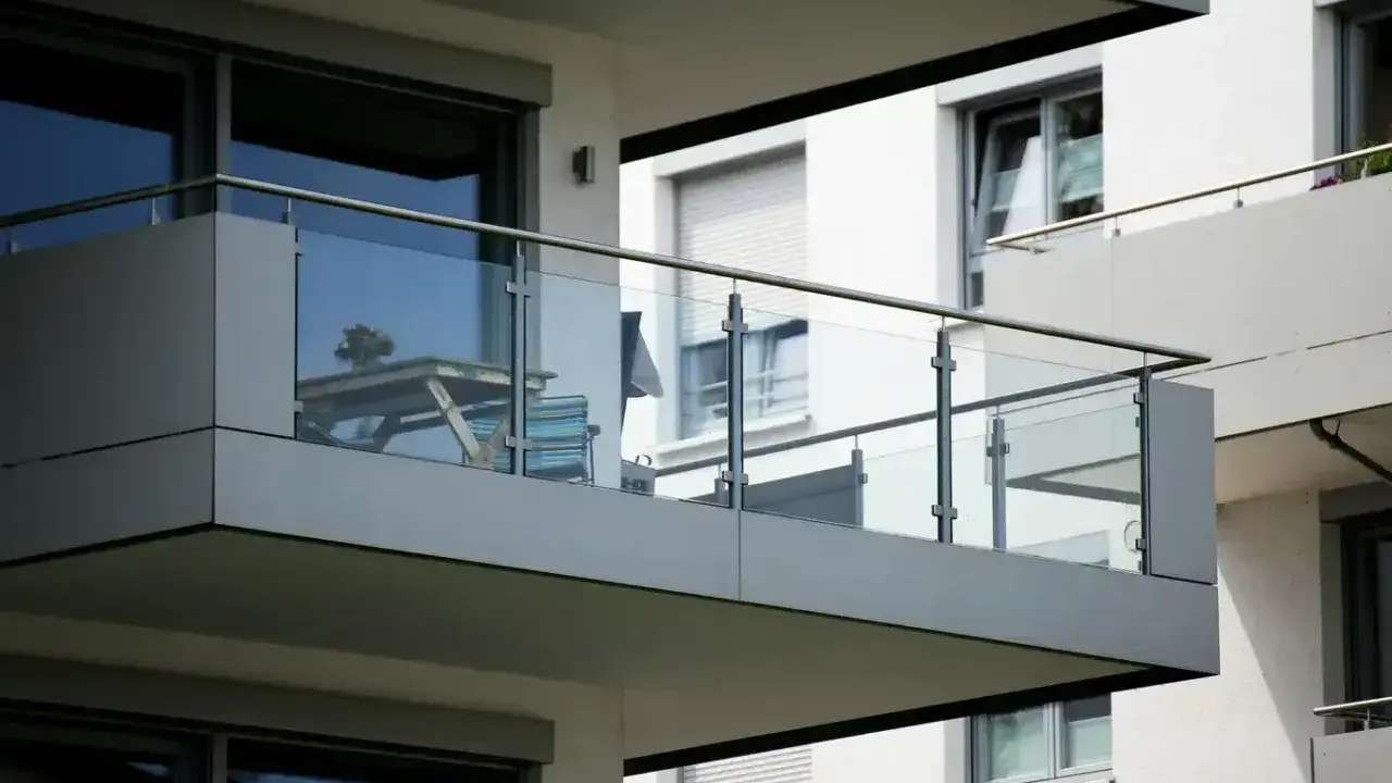 Nowoczesna loggia z przeszkloną balustradą, stolikiem i krzesłem. Idealne miejsce na poranną kawę.