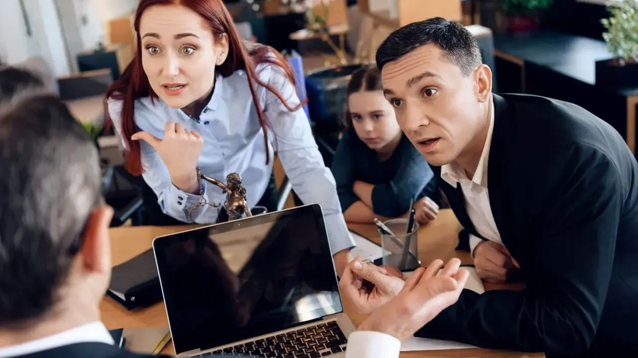 Rodzina w sądzie. Kobieta z wyrzutem wskazuje palcem, mąż kłamie na sprawie rozwodowej, a córka patrzy z niepokojem.