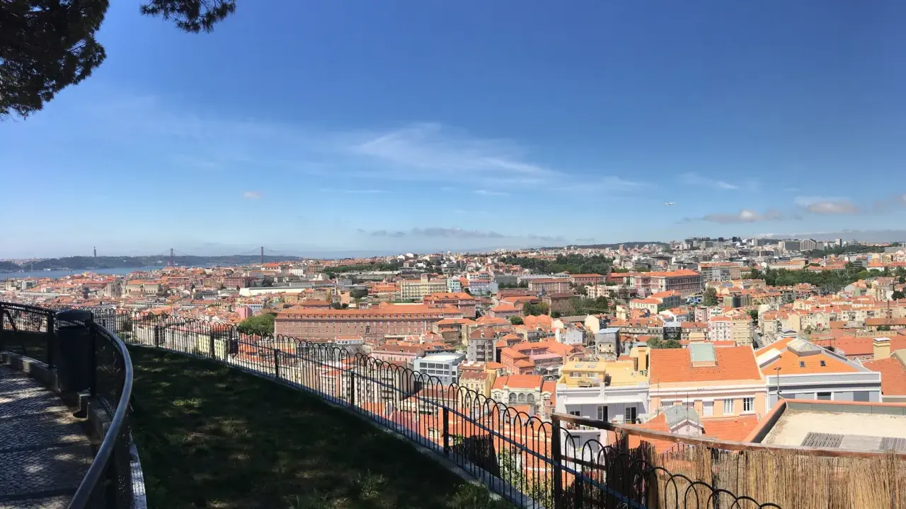 Blick vom Nossa Senhora do Monte auf Lissabon mit seinen roten Dächern und der Brücke im Hintergrund.