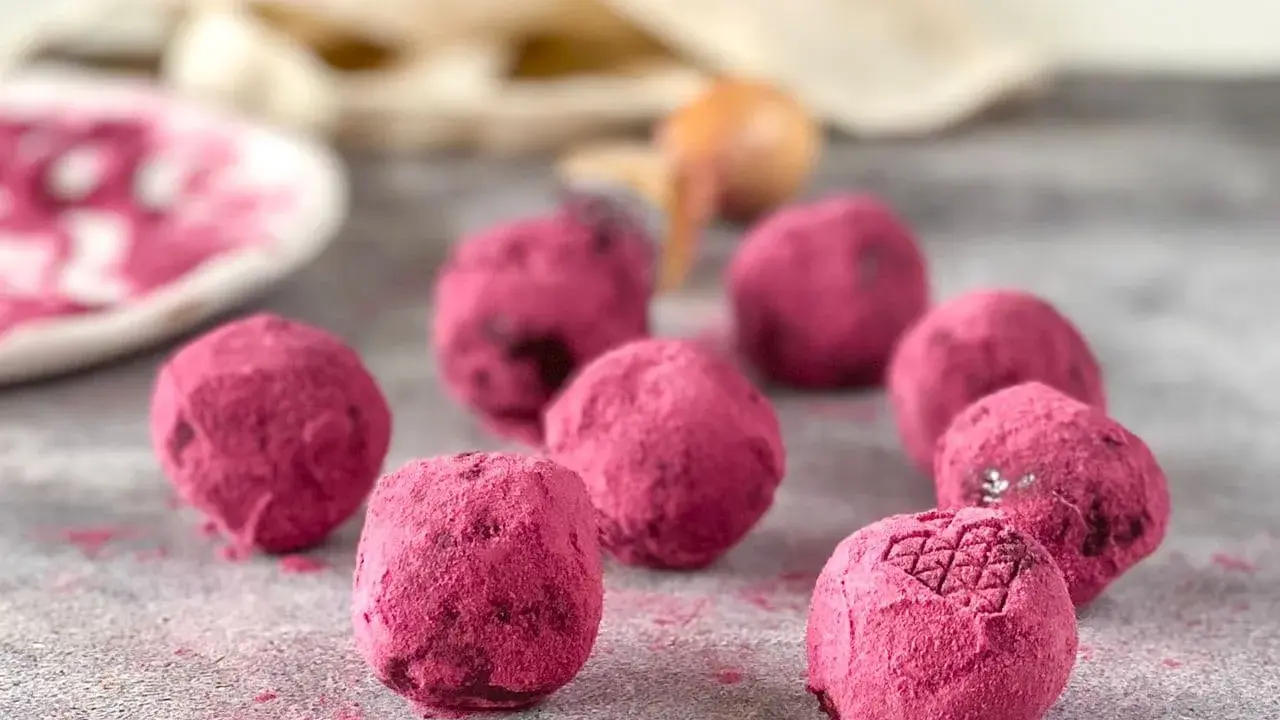 Deliciosas trufas de chocolate cubiertas de polvo rosa vibrante. Un bocado dulce y tentador.