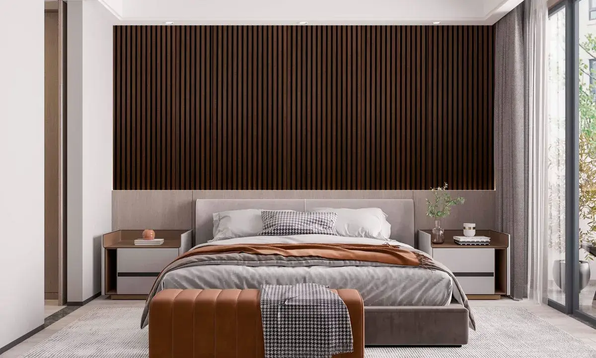 Sovrum panel inspiration: mörka träpaneler bakom en säng med grå sängkläder och en brun pall.