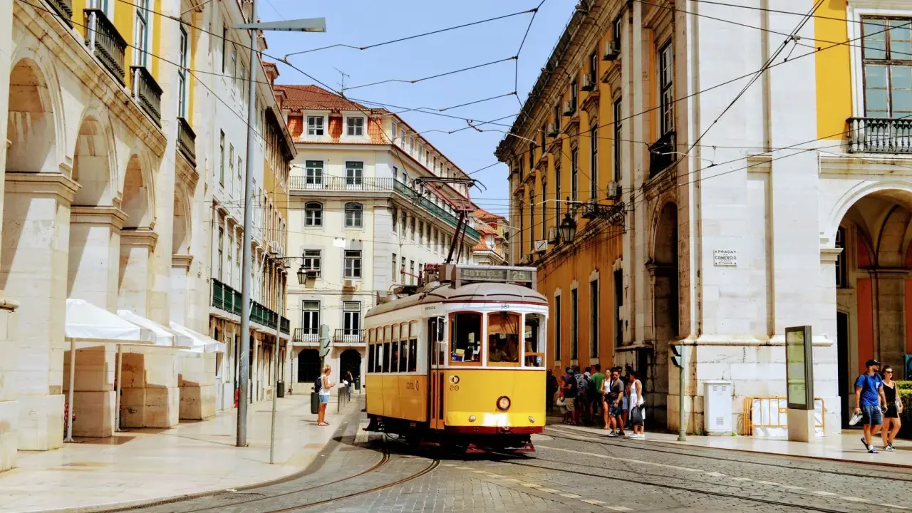 Gelber Oldtimer-Tram fährt durch Lissabon. Die Höchstgeschwindigkeit Portugals ist hier nicht relevant, aber die Atmosphäre ist unbezahlbar.