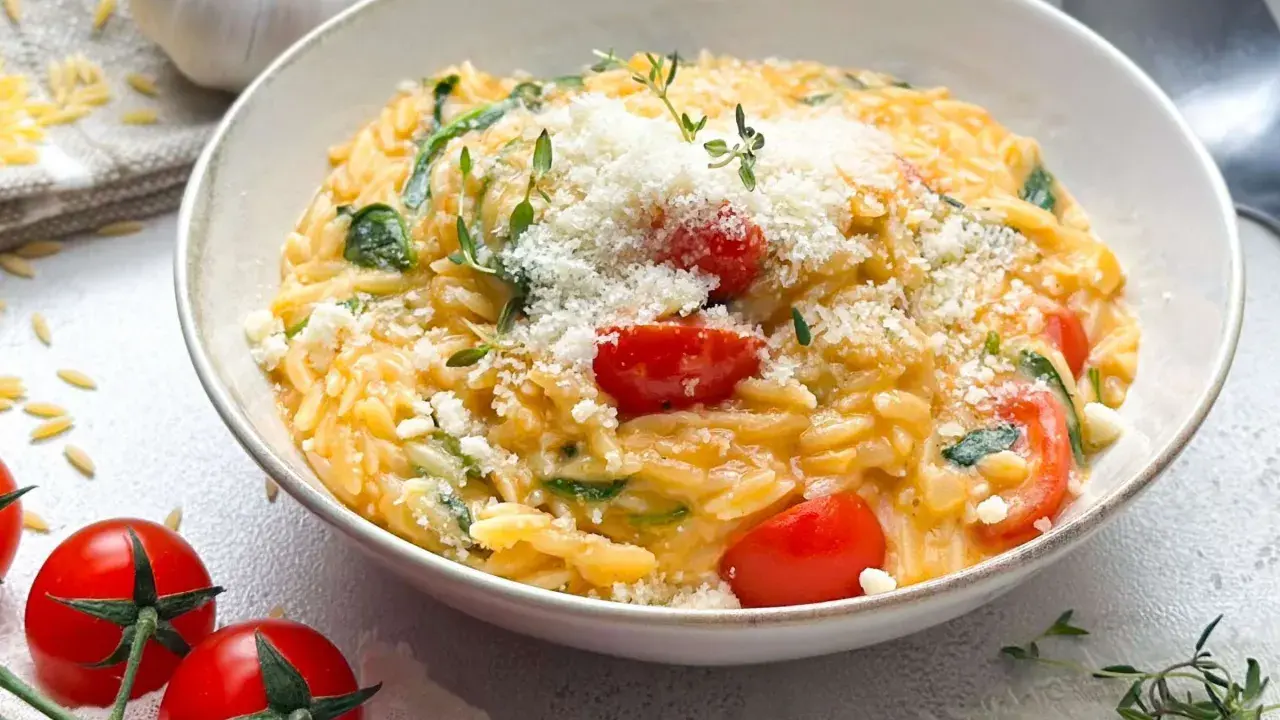 Cremiges Orzo-Rezept mit Kirschtomaten, Spinat und Parmesan. Ein köstliches Gericht, das schnell zubereitet ist.