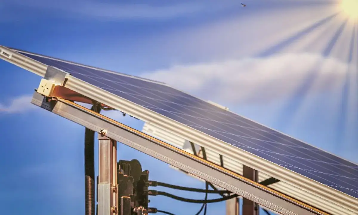 Ein Balkonkraftwerk MV fängt die Sonnenstrahlen ein. Der blaue Himmel mit Wolken und die Sonne im Hintergrund versprechen viel Energie.