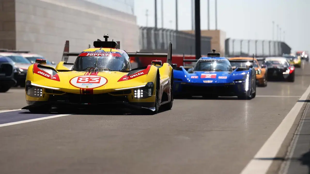 Gelber Ferrari Le Mans Hypercar mit Startnummer 83 und blauer Konkurrenz auf der Rennstrecke.