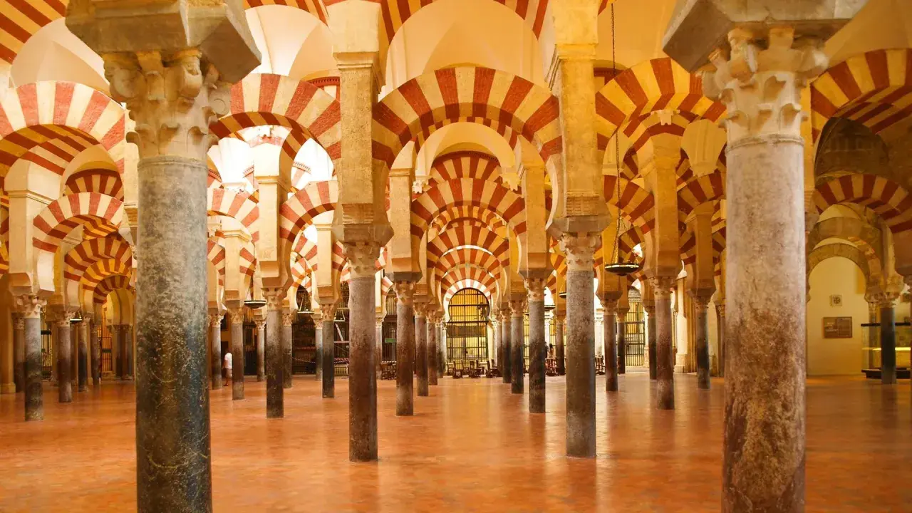 Ein Saal mit Säulen und roten und weißen Bögen, der an die Gelehrsamkeit arabischer Wissenschaftler erinnert.