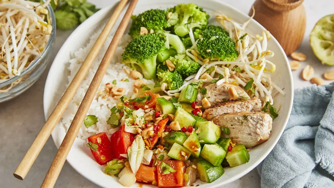 Ein bunter Asia Bowl mit Reis, Hähnchen, Brokkoli, Gurken, Tomaten und Sojasprossen. Perfekt für ein leichtes Mittagessen.