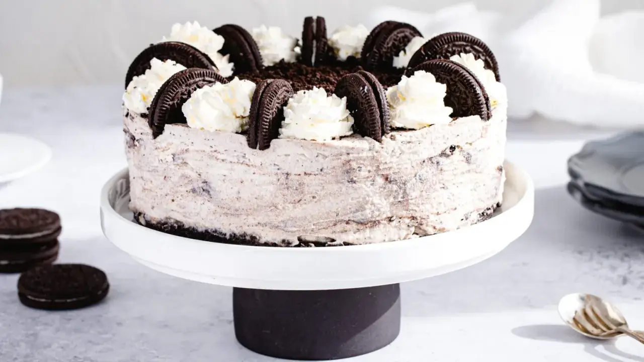Pyszny sernik oreo na zimno, udekorowany bitą śmietaną i ciasteczkami. Idealny deser na upalne dni.