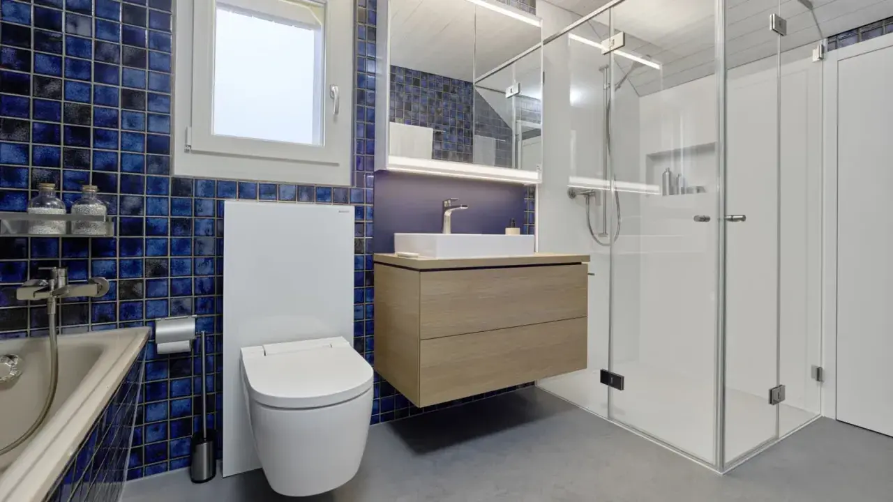 Modernt badrum med blå mosaik, flytande kommod och duschkabin. Perfekt badrum inspiration för ett stilrent hem.