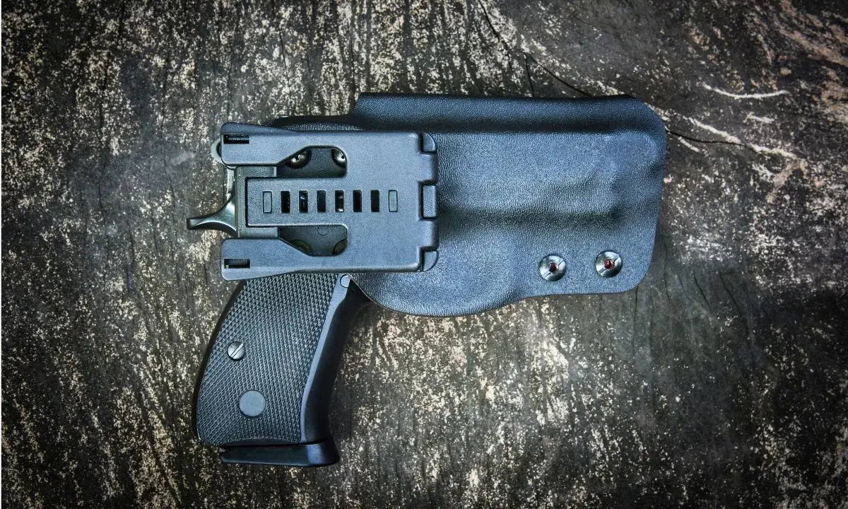 Czarna kabura wewnętrzna na broń, dyskretnie ukrywająca pistolet.