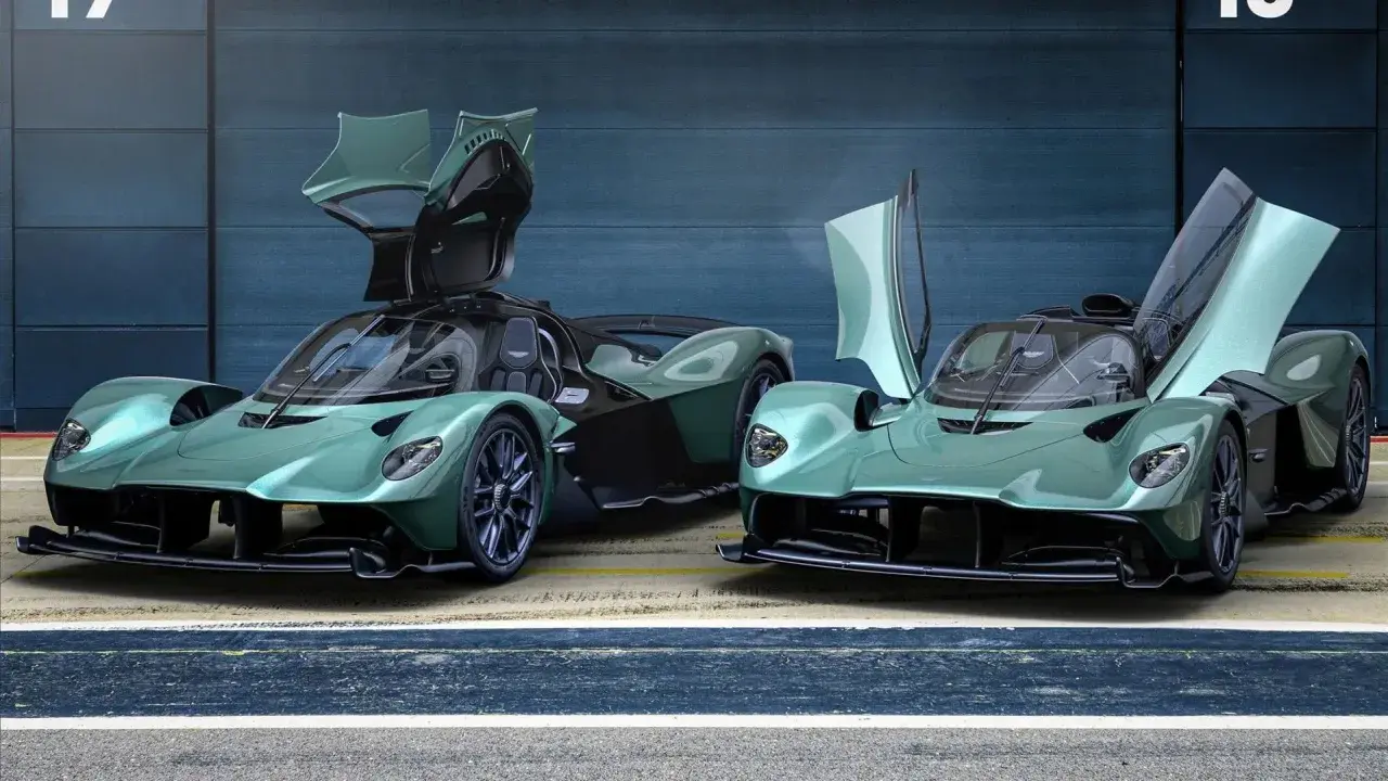 Zwei Aston Martin Valkyrie Spider in Mintgrün mit geöffneten Flügeltüren stehen nebeneinander.