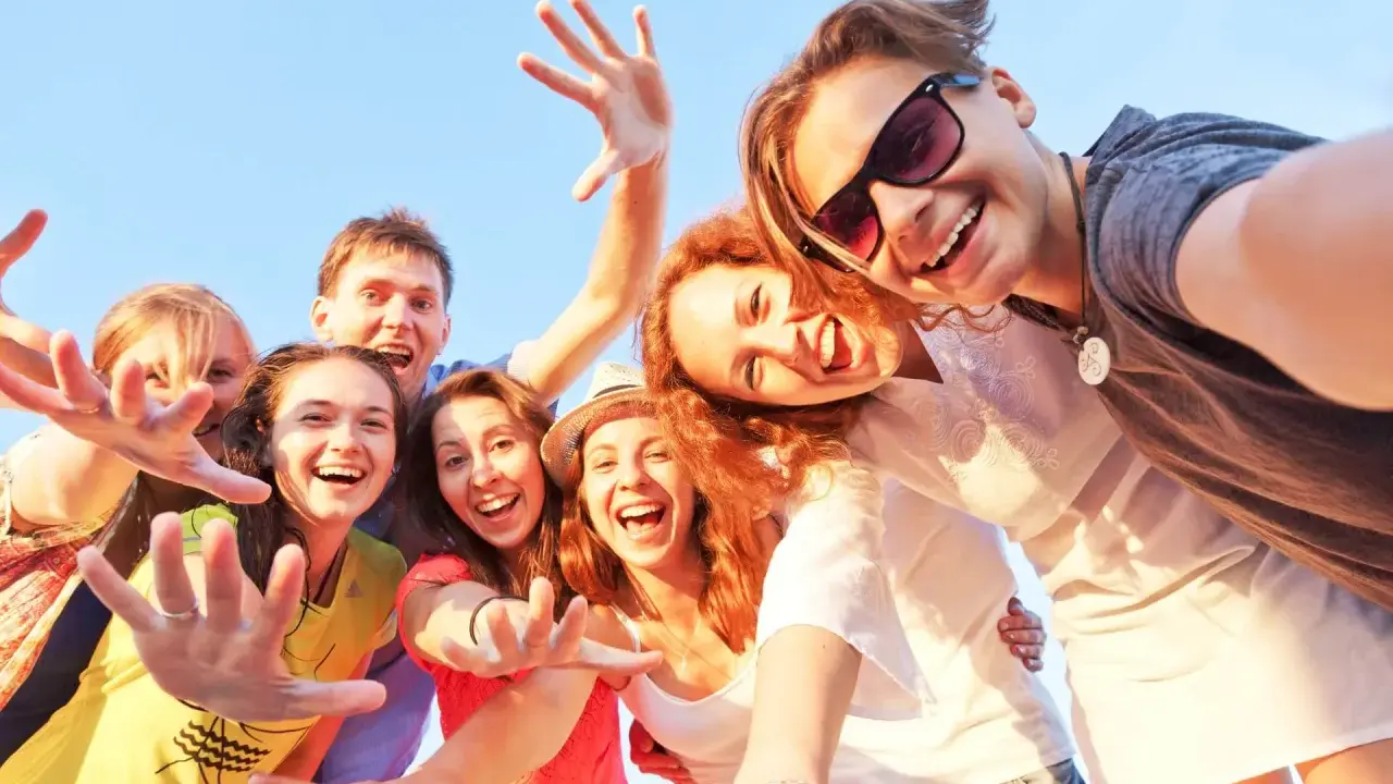 Uśmiechnięta grupa przyjaciół robi selfie. Ich radość i bliskość to czynniki chroniące przed samotnością.