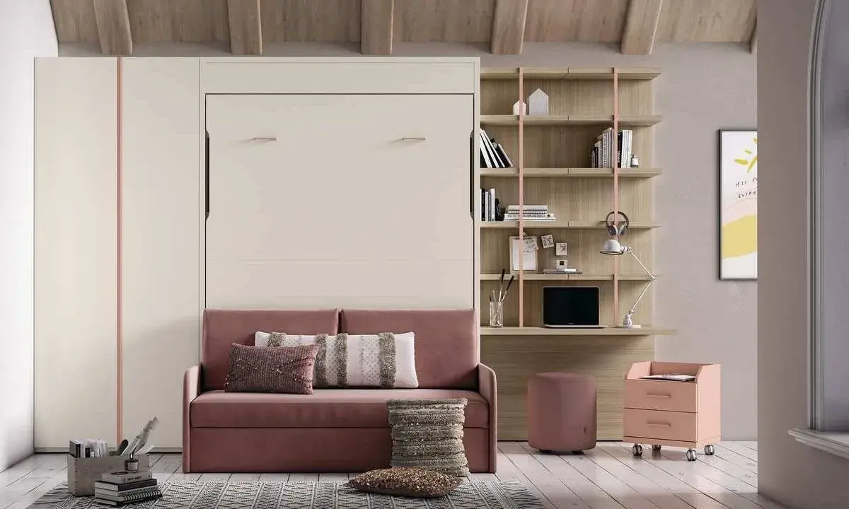 Sofá rosa con cojines, junto a una estantería y una **cama nido vertical** oculta.