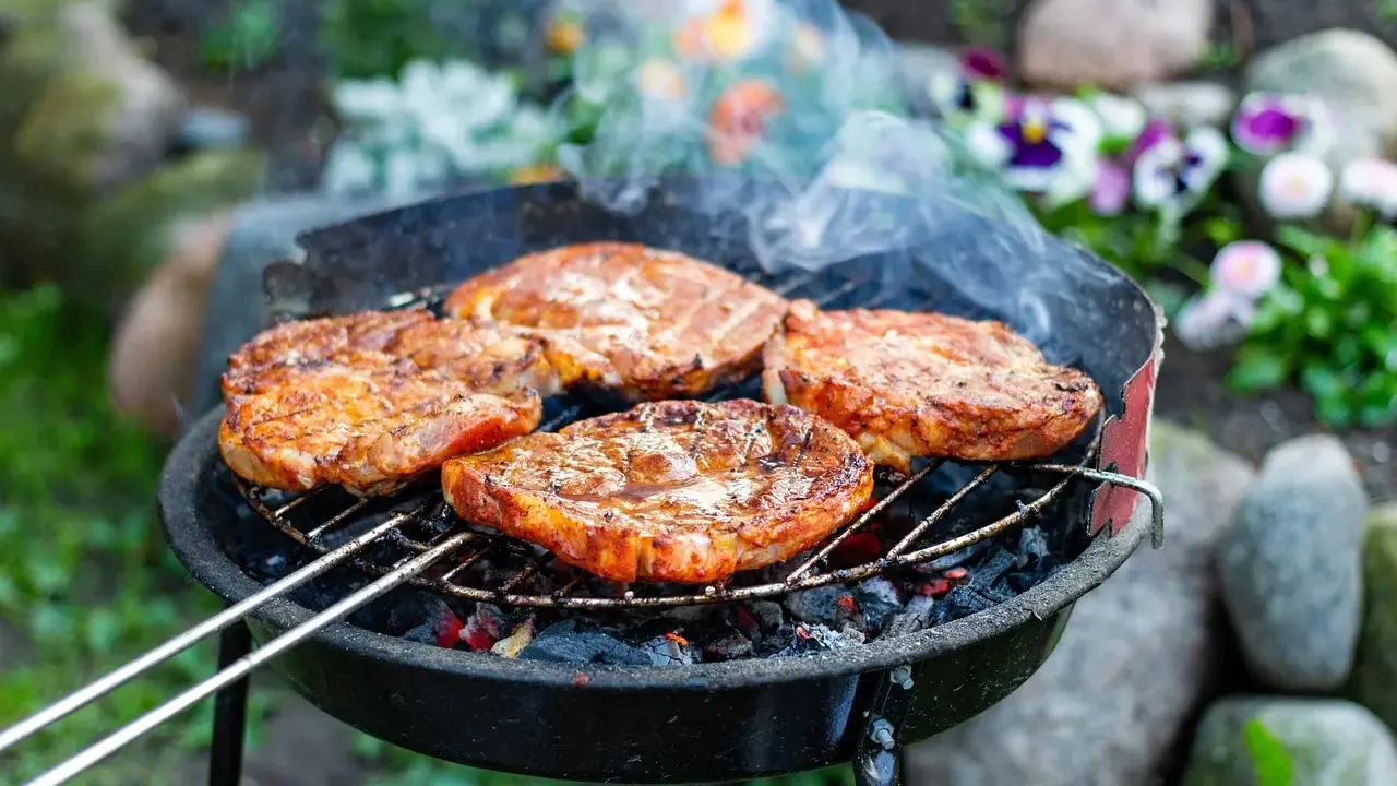 Saftige Steaks brutzeln auf dem Grill. Das Aroma von gegrilltem Fleisch liegt in der Luft.