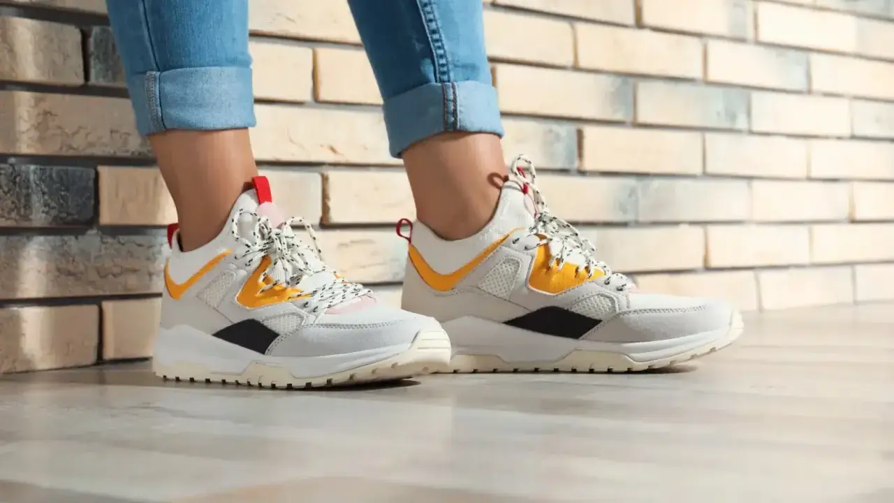 Białe sneakersy z żółtymi i czarnymi akcentami, idealne do jeansów. Czy to HOFF buty? Co to za firma?