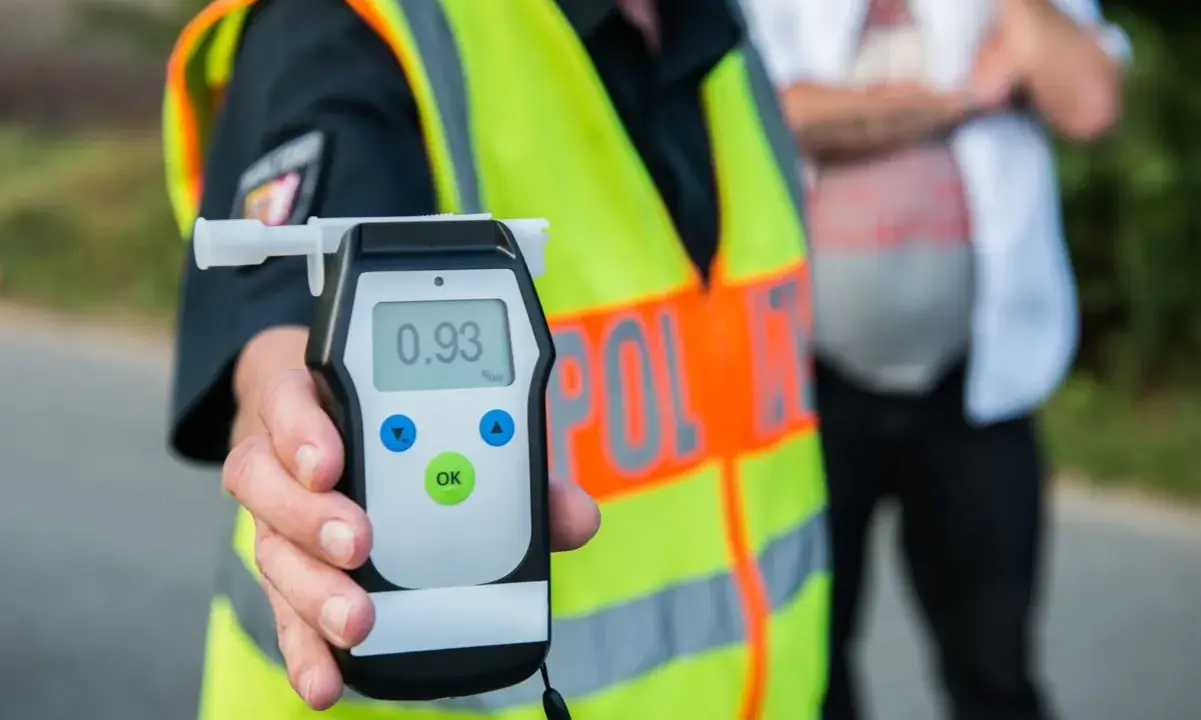Policjant pokazuje alkomat z wynikiem 0.93 promila. Kontrola trzeźwości to ważny element bezpieczeństwa na drogach.