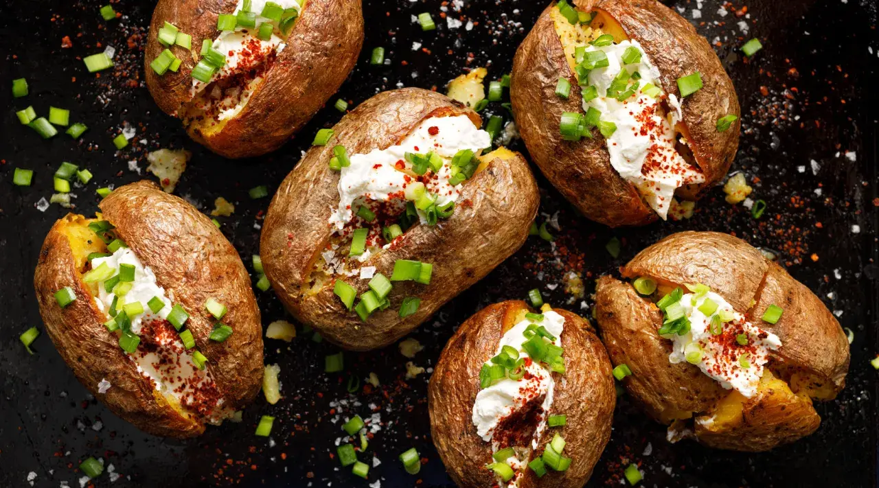 Kumpir Rezept: Gebackene Kartoffeln mit cremiger Füllung, Schnittlauch und Paprikapulver.