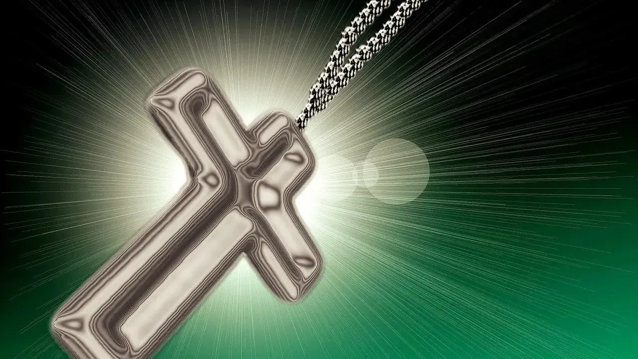 Srebrny krzyż na łańcuszku, symbol wiary, jak tekst psalmu 62, rozświetla mrok.