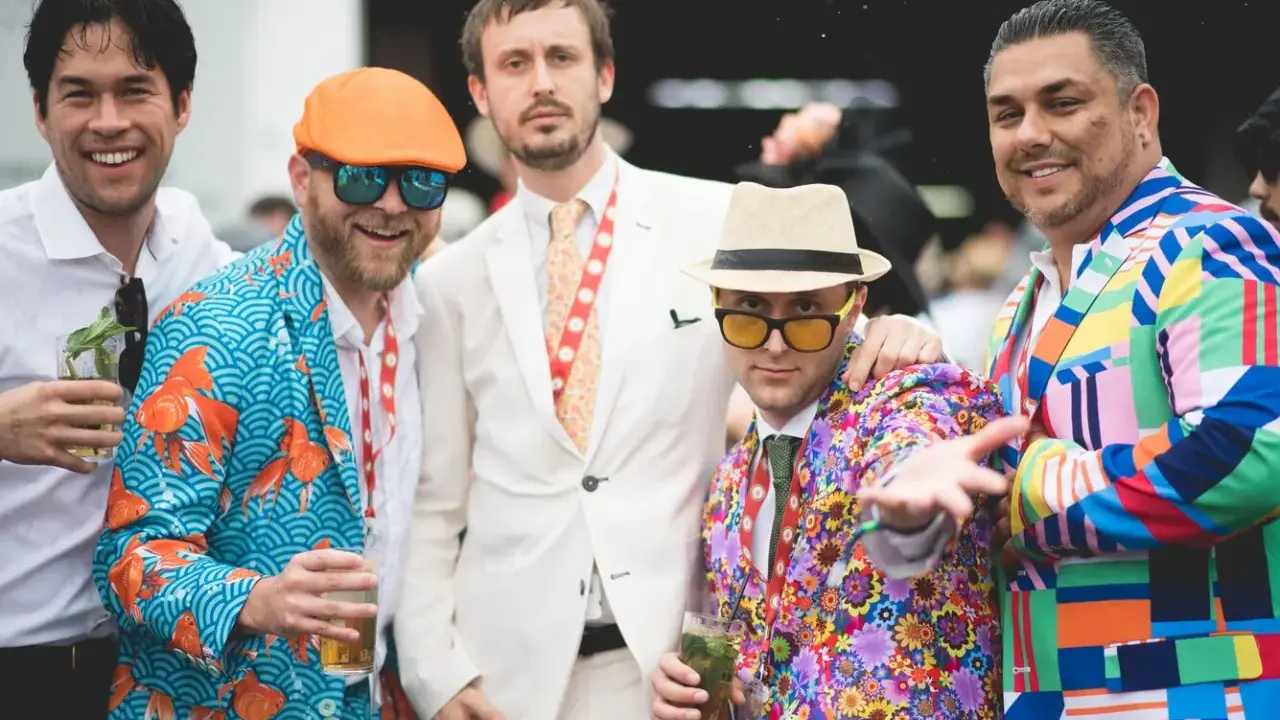 Men at the Kentucky Derby sport vibrant, patterned suits, showcasing bold fashion choices.
