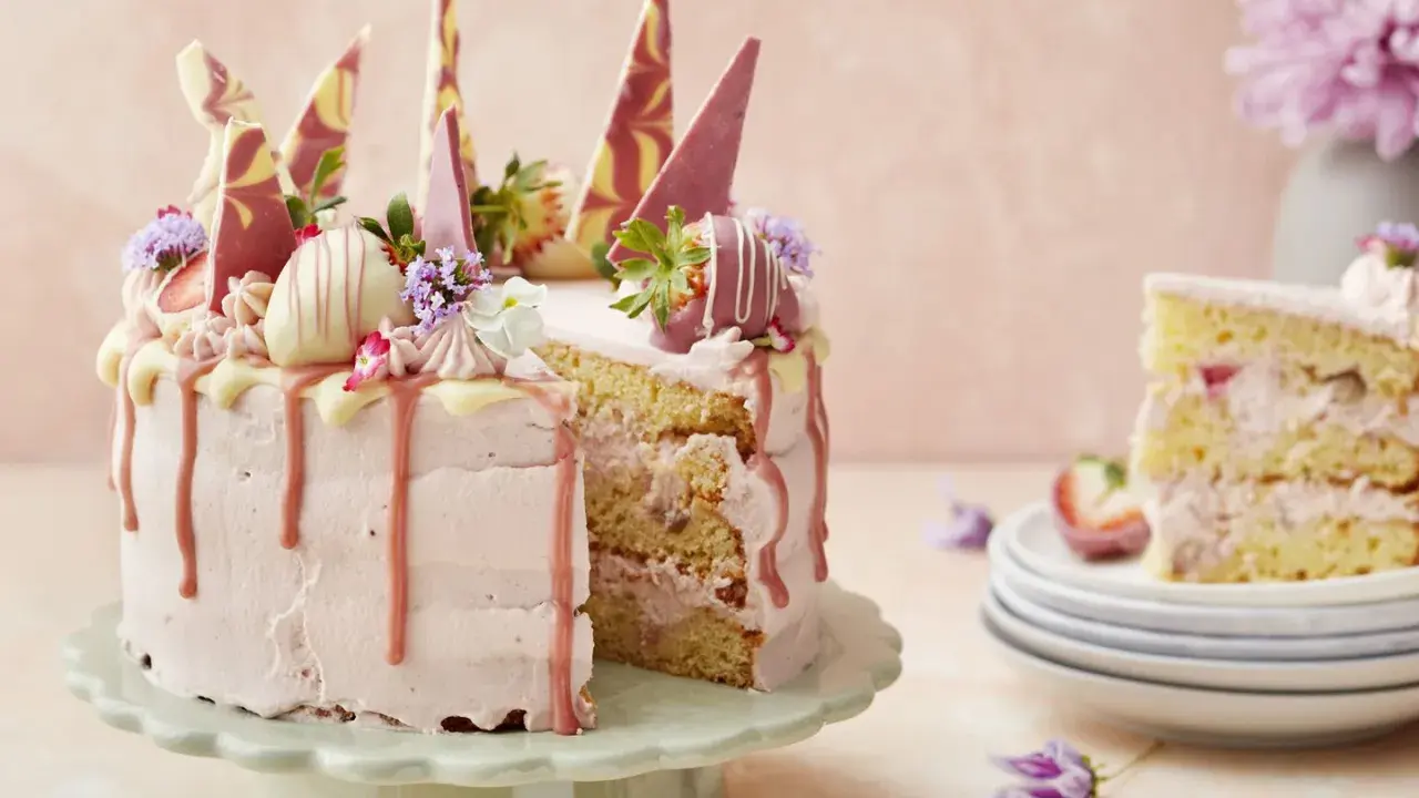 En vacker tårta med rosa frosting, jordgubbar och chokladdekorationer. Perfekt för att dekorera tårta till ett speciellt tillfälle.