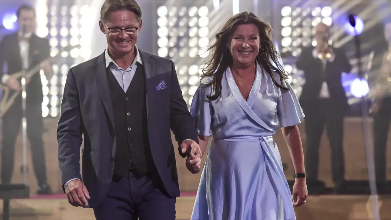 Lotta Engberg och ett leende raffset på scenen, med ett band i bakgrunden.