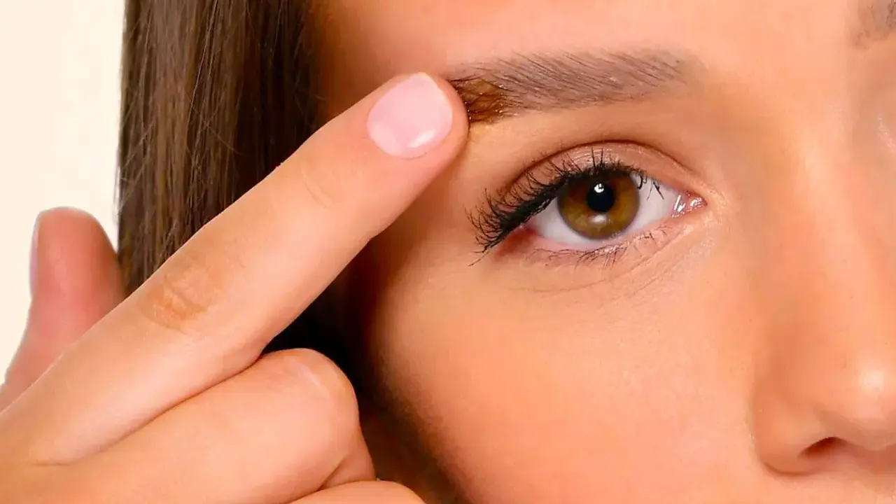 Un doigt applique un produit sur un sourcil, montrant a quoi servent les sourcils : protéger les yeux et exprimer les émotions.