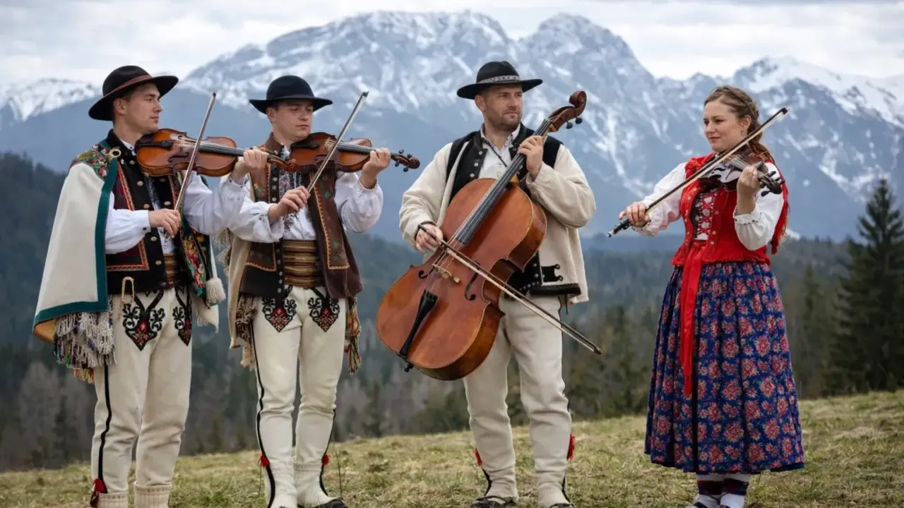Muzykanci w strojach góralskich grają na instrumentach, prezentując żywą kulturę podhala.