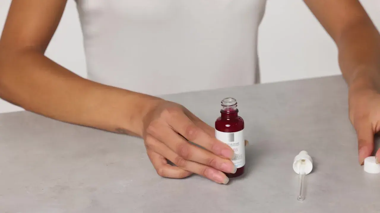 Mani che mostrano il siero Retinol B3 La Roche Posay, pronto per l'uso. Scopri come applicarlo per una pelle radiosa.