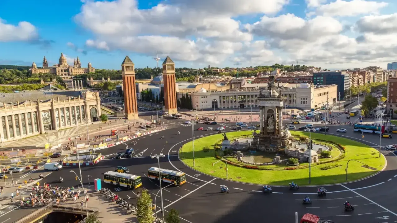Widok na plac z fontanną i wieżami, idealny na weekend w Barcelona.