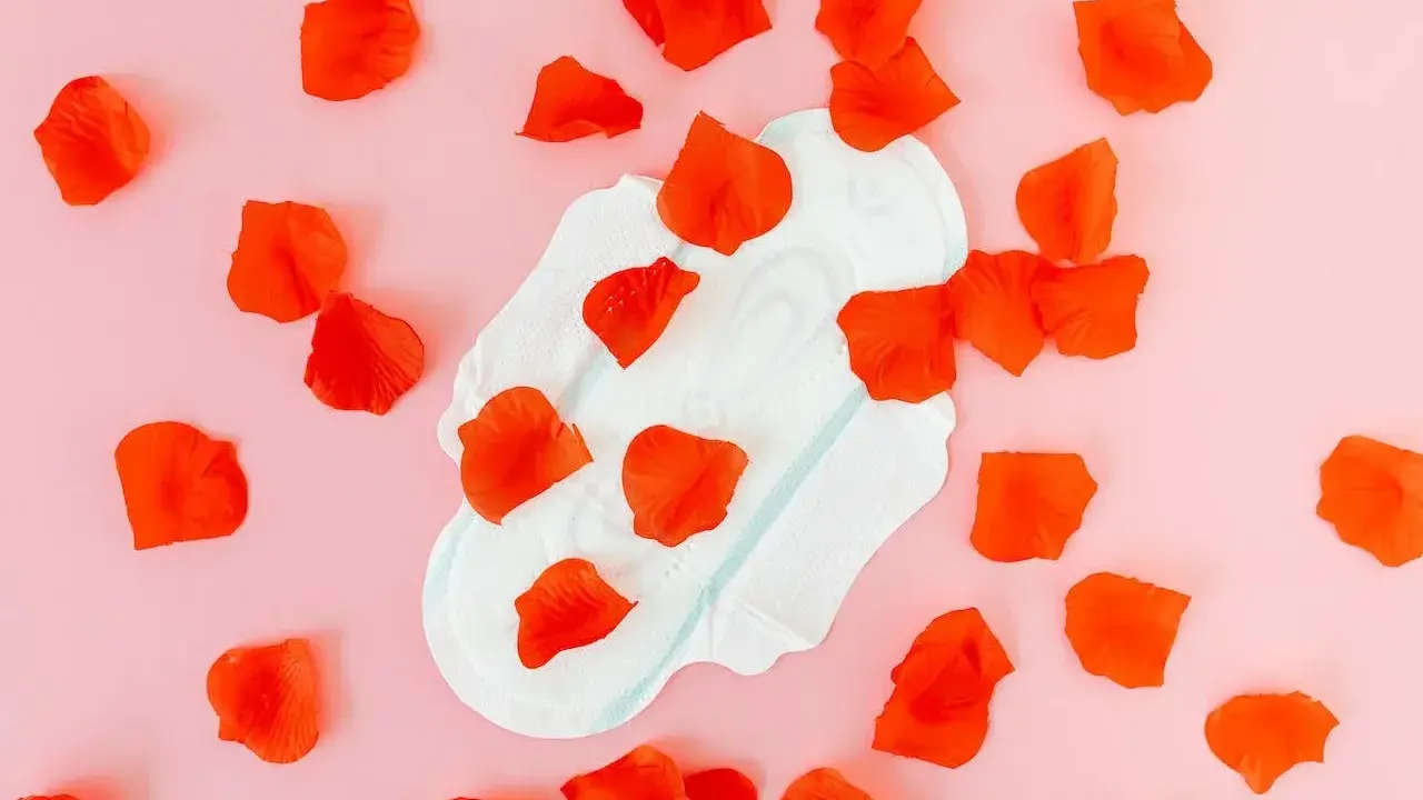 Compresa con pétalos rojos, simbolizando el sangrado después de la pastilla del día después.