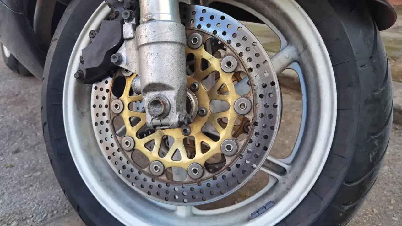 Motocykl z tarczami hamulcowymi i zaciskiem. Ostre koło hamowanie zapewnia bezpieczeństwo na drodze.