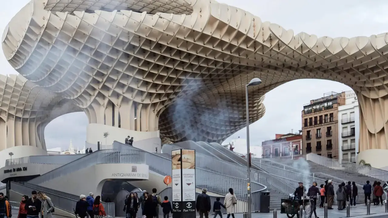Ein Meisterwerk des Dekonstruktivismus: die Metropol Parasol in Sevilla. Menschen schlendern unter der organisch geformten Holzkonstruktion hindurch.