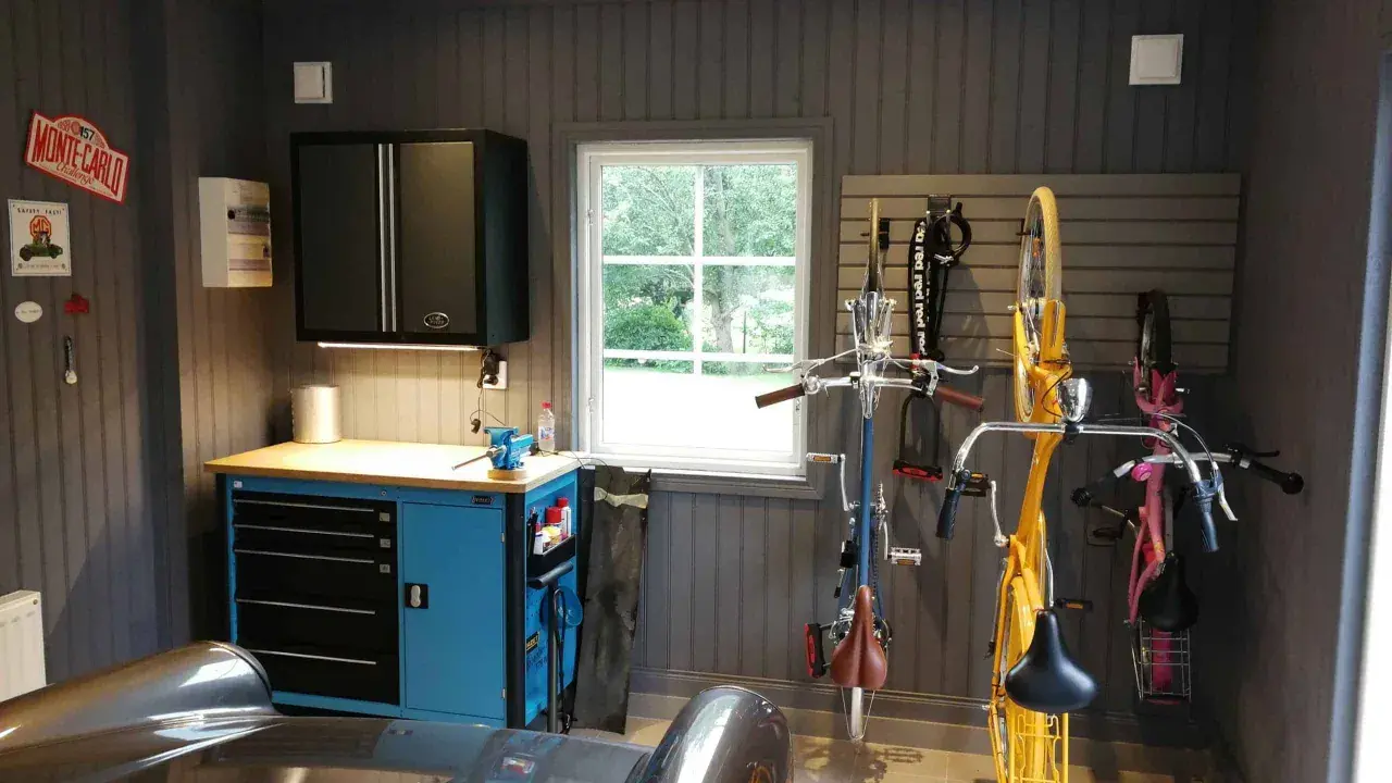 Snygga garage med cyklar upphängda, verktygsskåp och en bil. Perfekt garage inspiration för den som gillar ordning och reda.