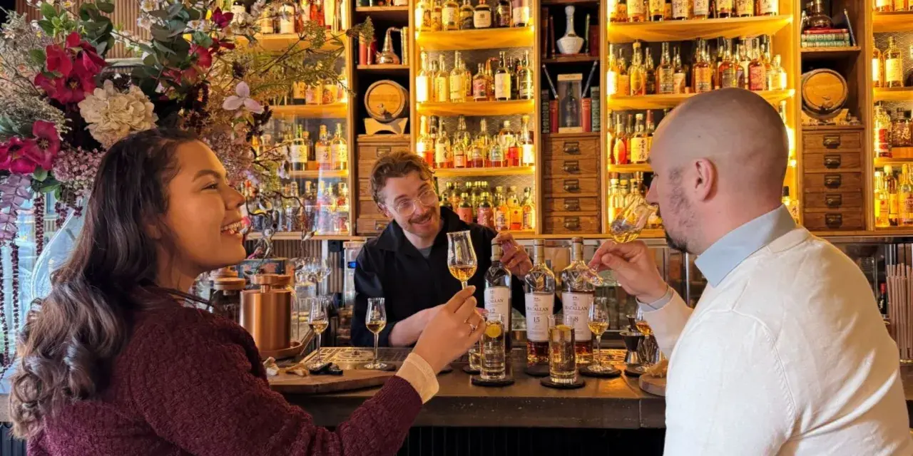 Två personer njuter av en ölprovning i Stockholm. En glad bartender serverar.