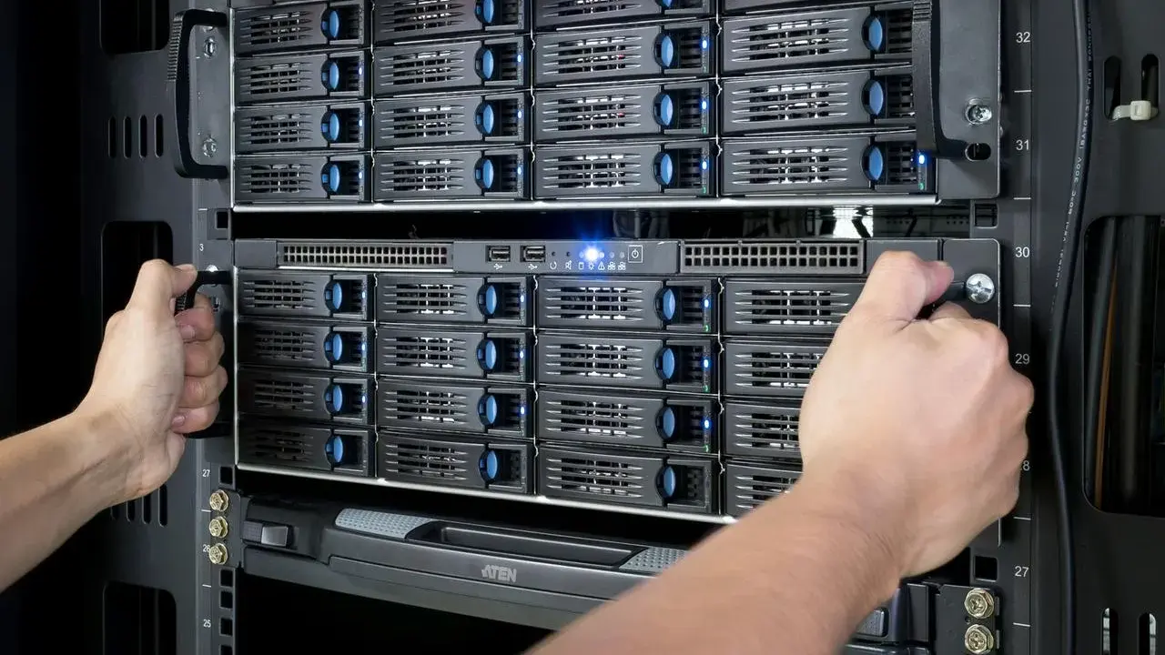 Mains d'un technicien installant des disques dans un nas server.