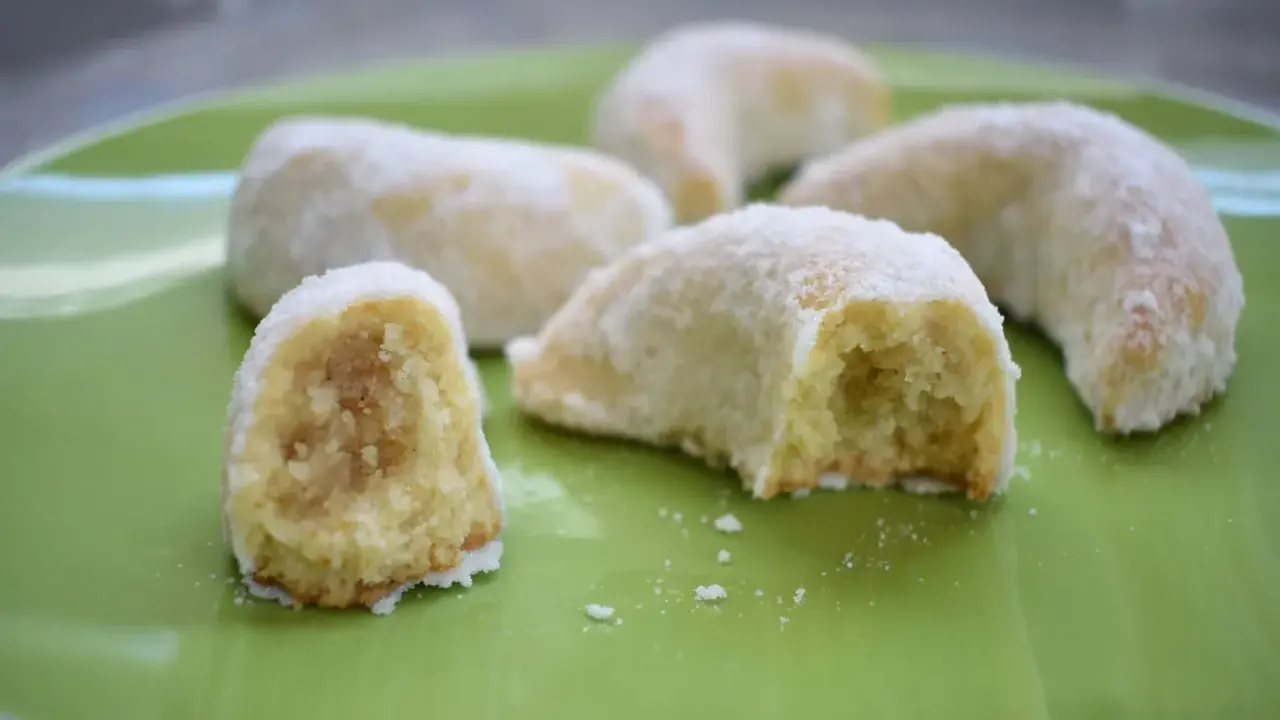 Délicieux biscuits en forme de croissant, saupoudrés de sucre glace, parfaits pour accompagner une tasse de thé. Une recette de corne de gazelle à essayer !