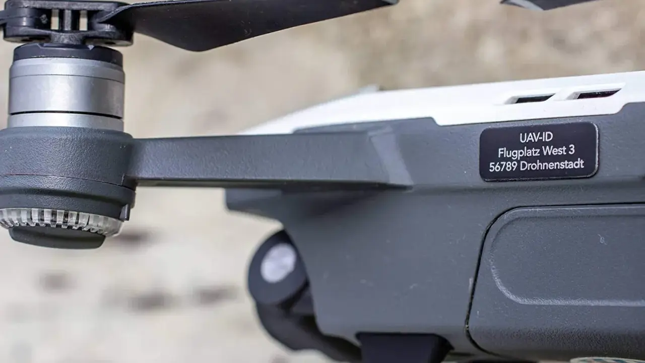 Nahaufnahme einer e-id drohne mit Propeller und Aufkleber "UAV-ID Flugplatz West 3 56789 Drohnenstadt".