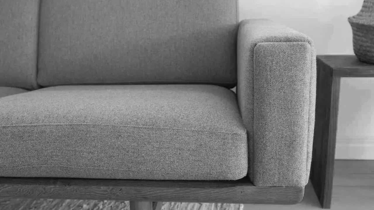 Grå soffa med trästomme, ett exempel på tidlös design möbler second hand.