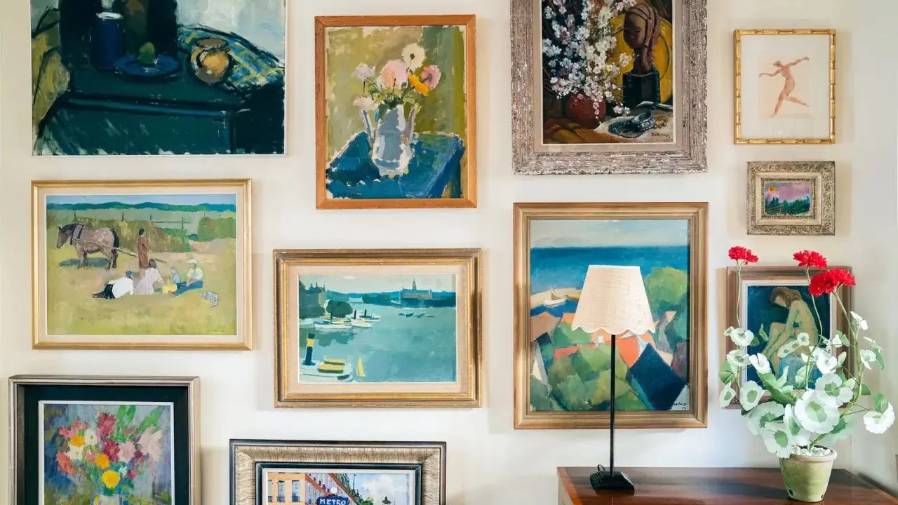 A gallery wall showcasing a diverse collection of paintings, proving that collecting art on a budget can create a vibrant and personal space.