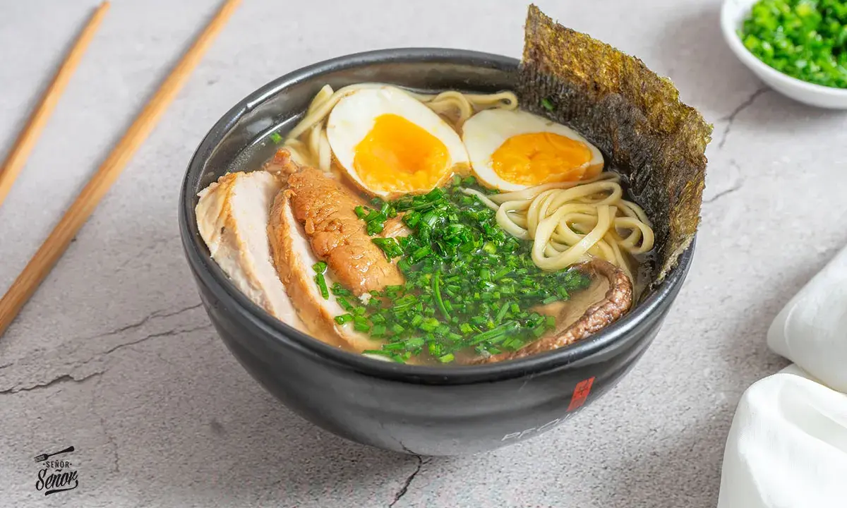 Un delicioso tazón de ramen con fideos, huevo cocido, carne de cerdo, cebollín y alga nori. Una tentadora receta ramen lista para disfrutar.