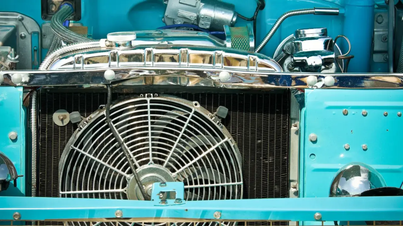 Motor de coche azul brillante con ventilador grande. ¿Por qué no salta el ventilador del coche? Quizás necesite un ajuste.
