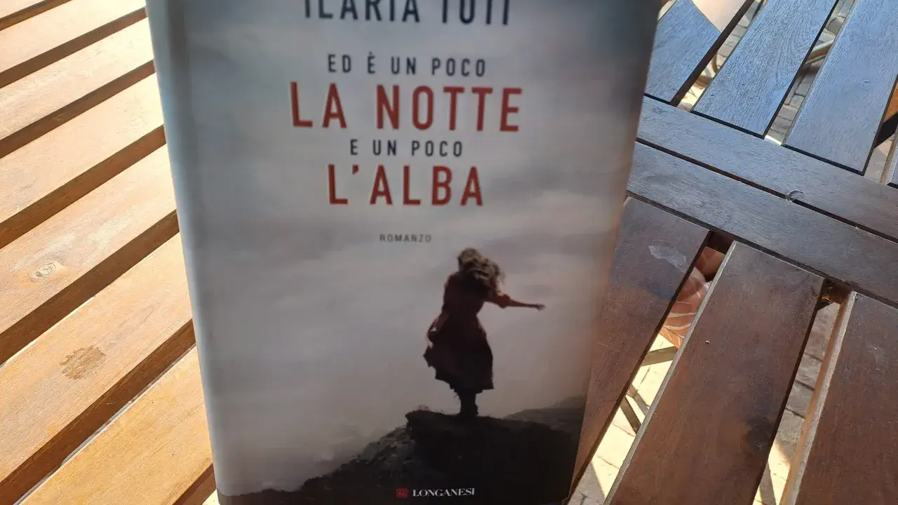 Copertina del libro "Ed è un poco la notte e un poco l'alba" di Ilaria Tuti, con una figura femminile su uno sfondo nebbioso.