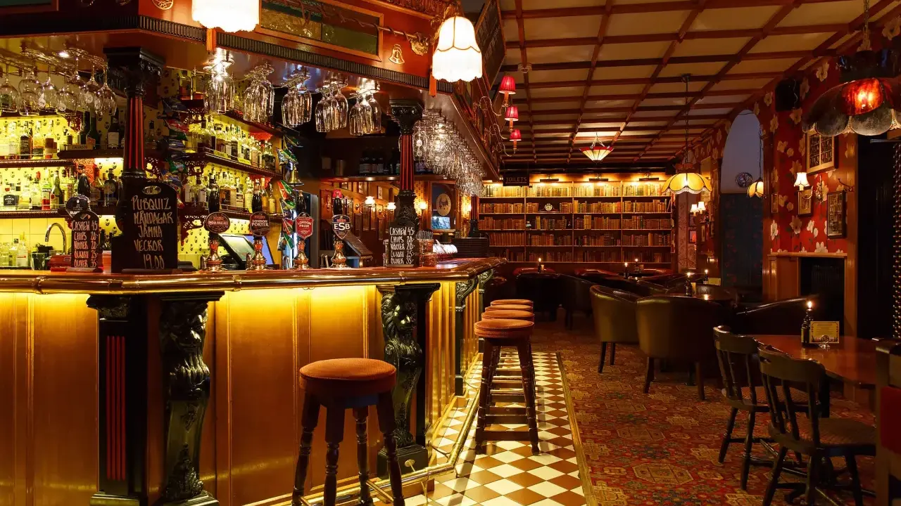 Mysig bar med bokhyllor och bekväma sittplatser, perfekt för att upptäcka Stockholms bästa barer.
