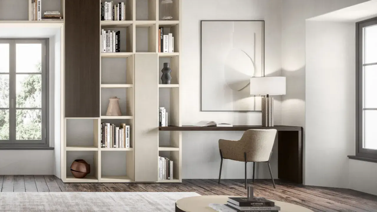 Angolo studio in soggiorno ricavato da libreria componibile. Scrivania integrata, sedia, lampada e quadro astratto.