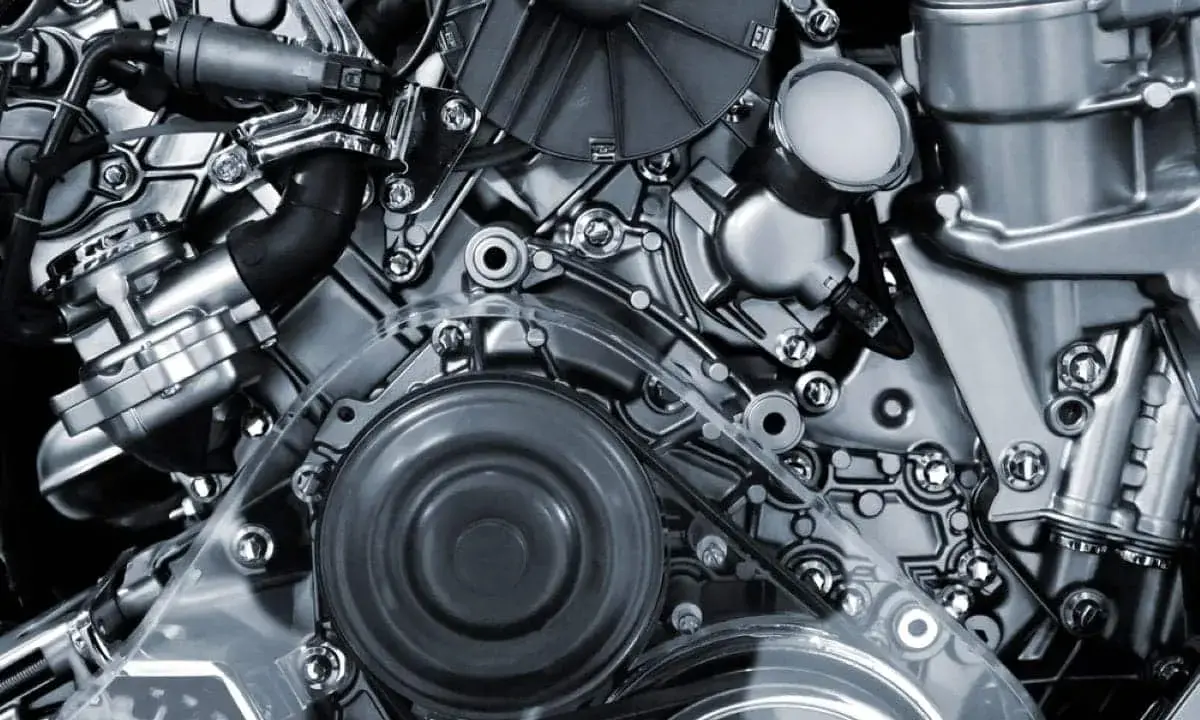 Detalle de un motor de cuatro tiempos, con correas, poleas y componentes metálicos pulidos.