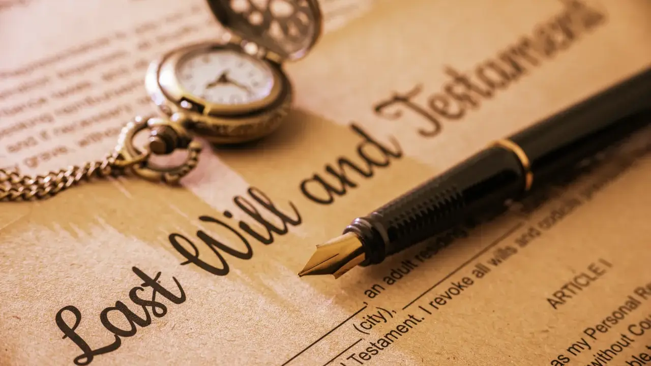 Otwarta kieszonkowa zegarek i pióro na dokumencie "Last Will and Testament".
