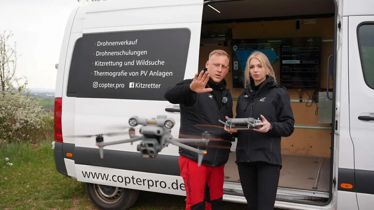 Männer und Frauen mit Drohnen-Fernbedienung vor einem Lieferwagen, der für Drohnenschulungen in Deutschland wirbt.