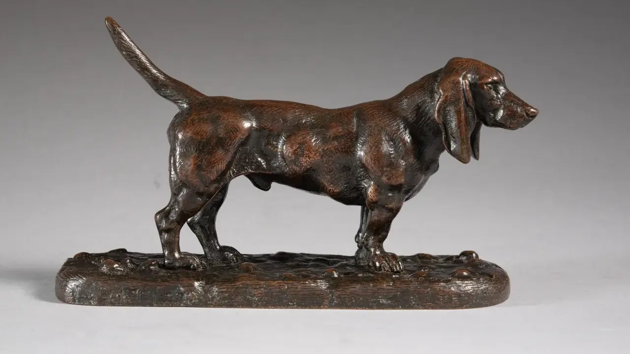 Une sculpture en bronze d'un chien basset hound, une des œuvres d'art de Antoine-Louis Barye, sur un socle imitant le sol.